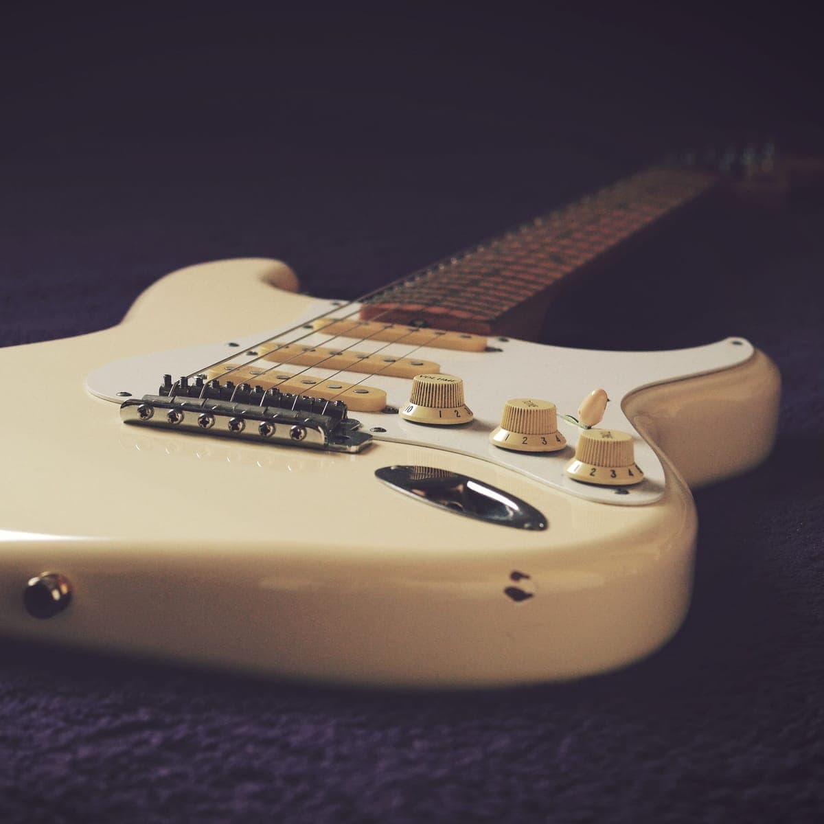 An electric guitar body resting in low light.