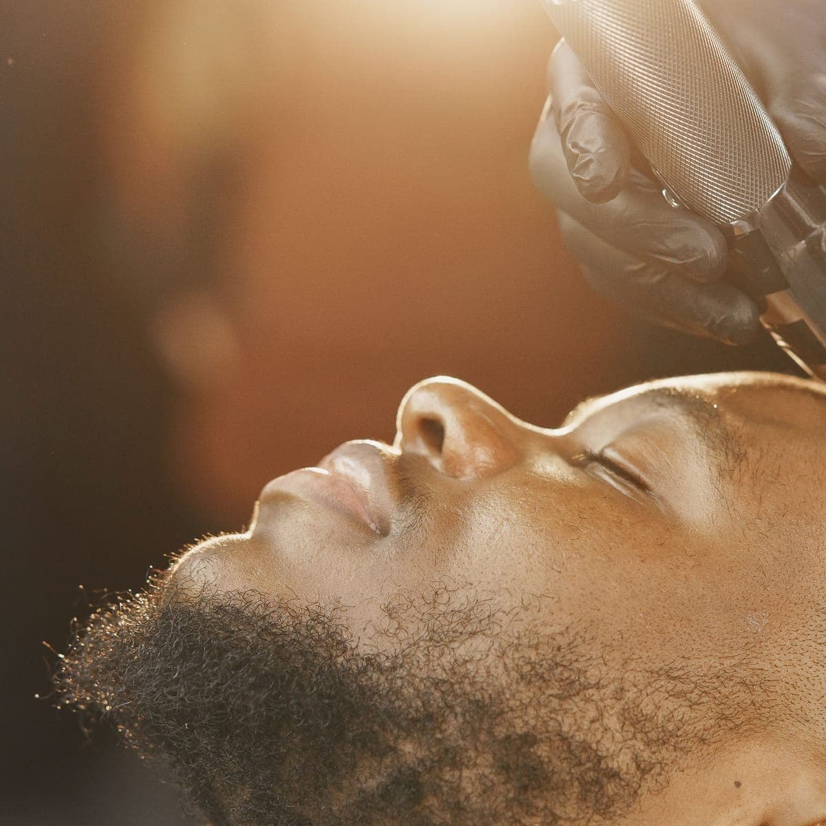 A client getting a clipper cut in warm light